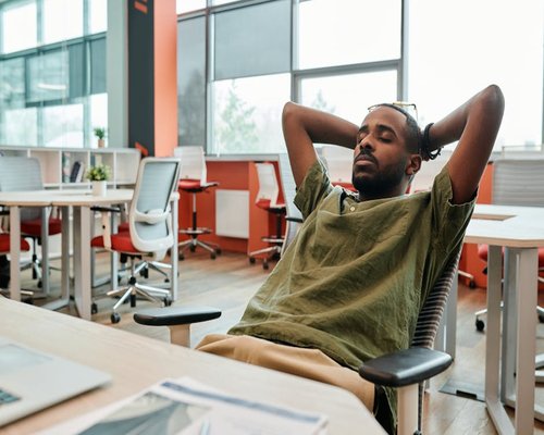 Person relaxing with eyes closed during break in Indonesian office