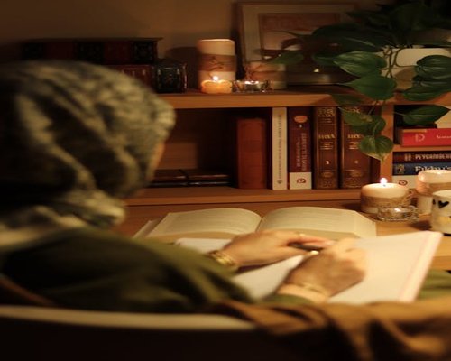 Reading a book in warm lamplight at Indonesian home